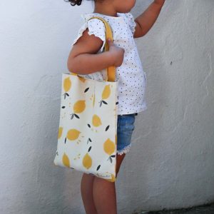 Niña mostrando mini bolsa de la compra de tela de limones - Limón & me